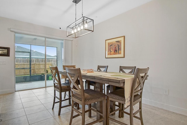 dining room featuring baseboards, a notable chandelier, and light tile patterned floors