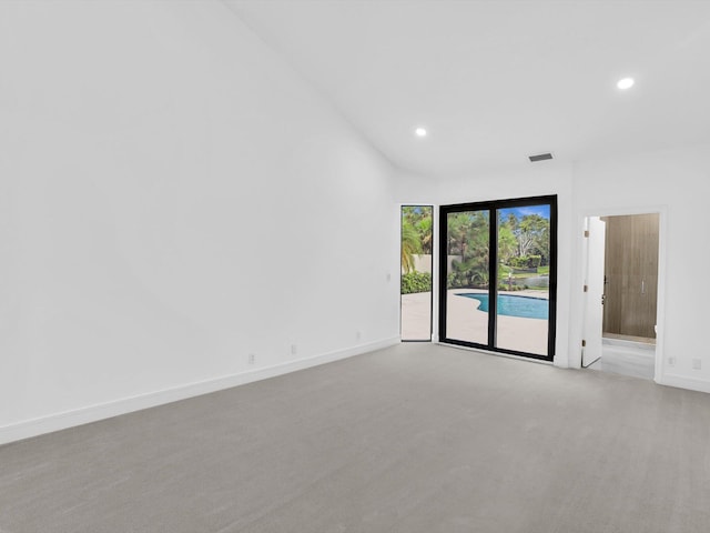 empty room with light colored carpet, recessed lighting, and baseboards