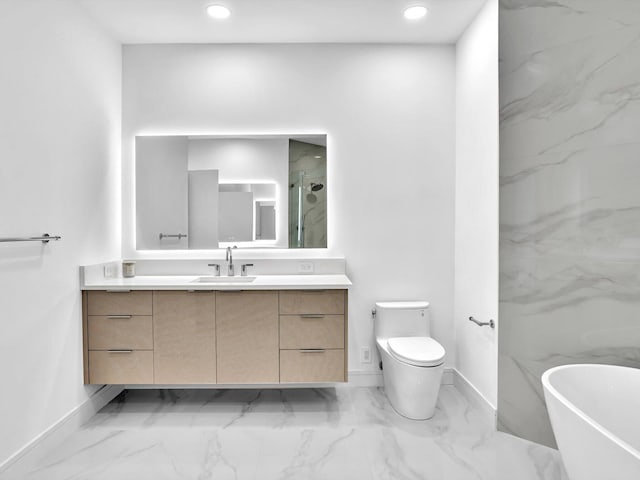 full bathroom featuring marble finish floors, vanity, a freestanding tub, baseboards, and toilet