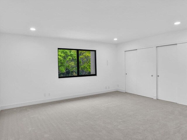 unfurnished bedroom featuring recessed lighting, carpet flooring, and a closet