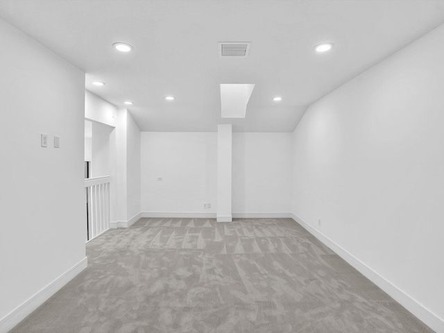 empty room featuring light colored carpet, recessed lighting, and baseboards