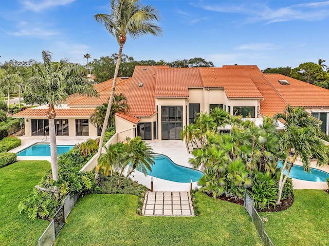 back of property featuring a tile roof, an outdoor pool, a sunroom, stucco siding, and a patio area
