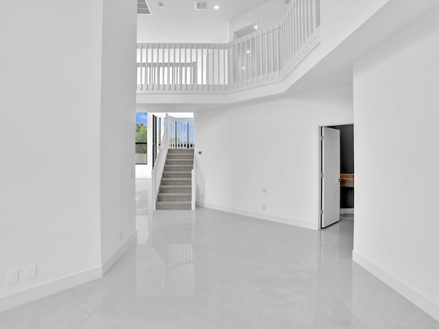 13759 Parc Dr, Palm Beach Gardens, FL 33410 - unfurnished living room featuring a high ceiling, baseboards, stairs, and marble finish flooring