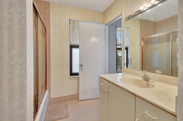 2430 NW 14th St, Delray Beach, FL 33445 - full bath featuring wallpapered walls, vanity, tile patterned floors, and bath / shower combo with glass door
