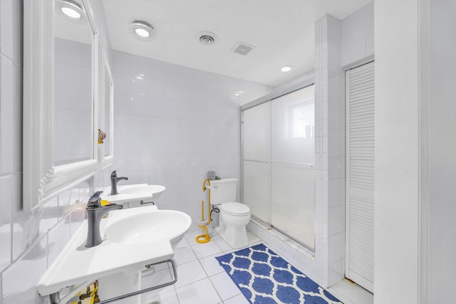 910 Dolphin Dr, Jupiter, FL 33458 - bathroom featuring tile walls, visible vents, toilet, tile patterned floors, and a sink