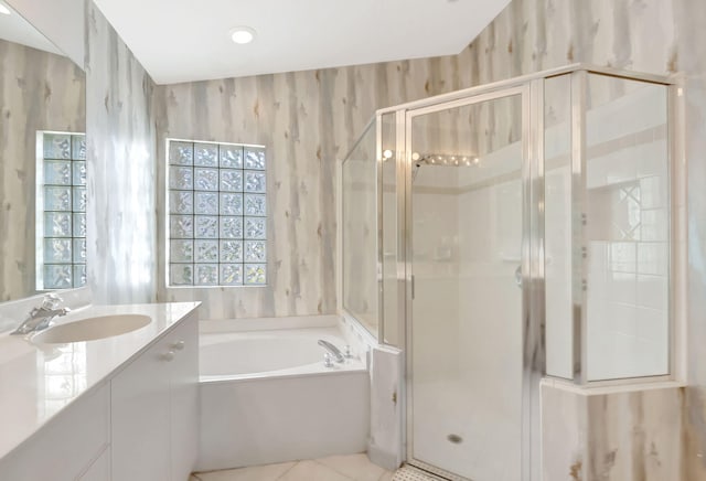 bathroom featuring vanity, a stall shower, a wealth of natural light, and a bath