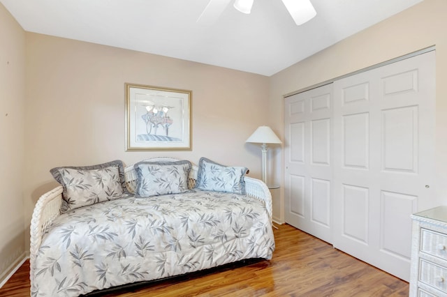bedroom with a ceiling fan, a closet, and wood finished floors