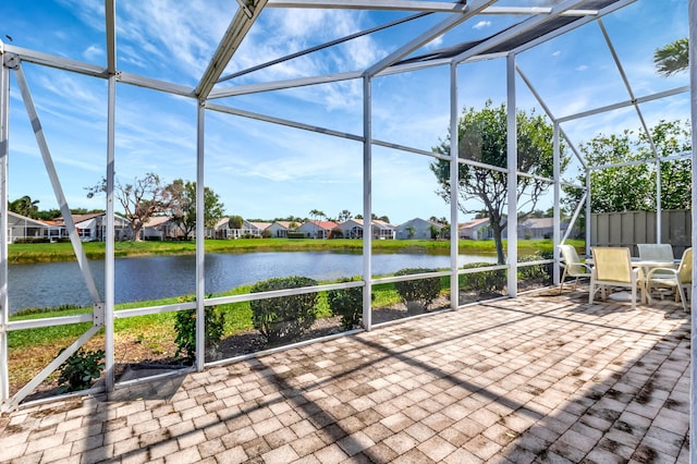 unfurnished sunroom with a residential view and a water view
