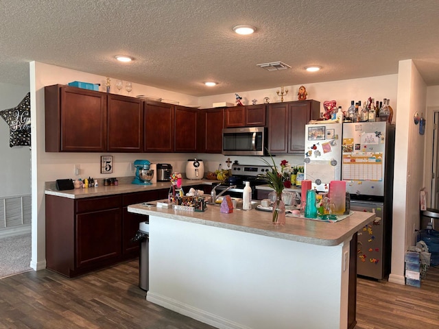 1938 SW Monterrey Ln, Port Saint Lucie, FL 34953 - kitchen with a textured ceiling, stainless steel appliances, visible vents, and dark wood-style floors