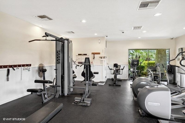 exercise room with a wainscoted wall, recessed lighting, and visible vents