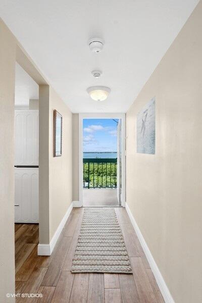 hallway featuring baseboards and light wood-type flooring
