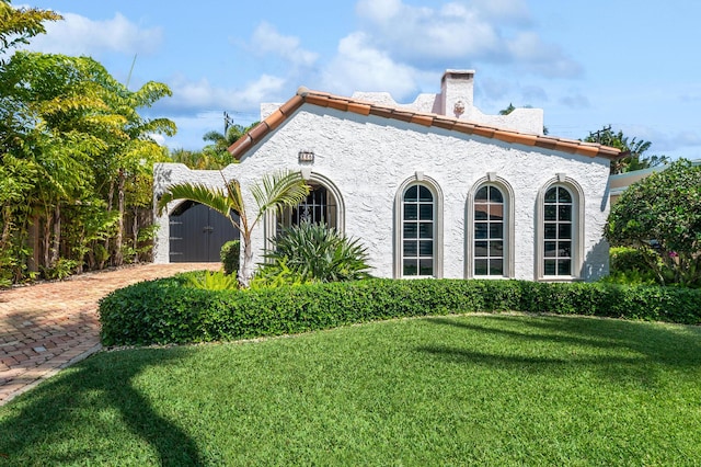 235 Nottingham Blvd, West Palm Beach, FL 33405 - view of side of property with a yard, a chimney, stucco siding, and a tile roof