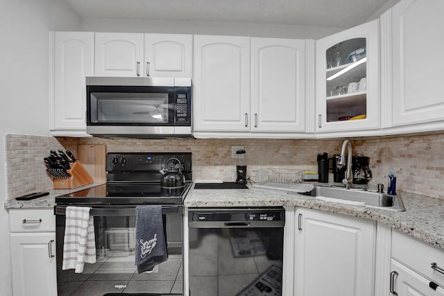 9441 W Mcnab Rd Unit 111, Tamarac, FL 33321 - kitchen featuring black appliances, glass insert cabinets, white cabinetry, and tasteful backsplash