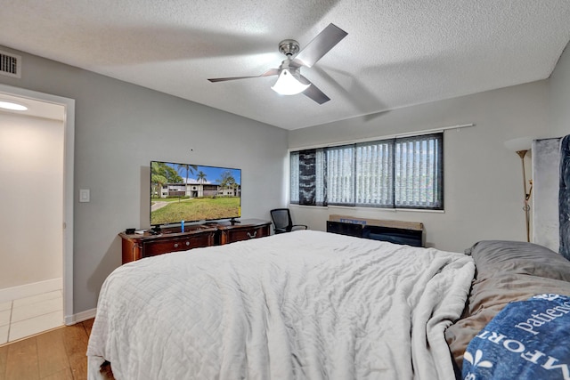 9441 W Mcnab Rd Unit 111, Tamarac, FL 33321 - bedroom featuring light wood-type flooring, a textured ceiling, and a ceiling fan
