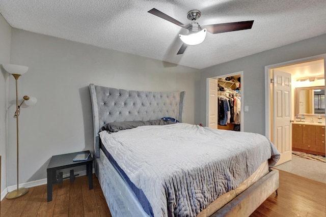 9441 W Mcnab Rd Unit 111, Tamarac, FL 33321 - bedroom with wood finished floors, a textured ceiling, a walk in closet, a closet, and ceiling fan