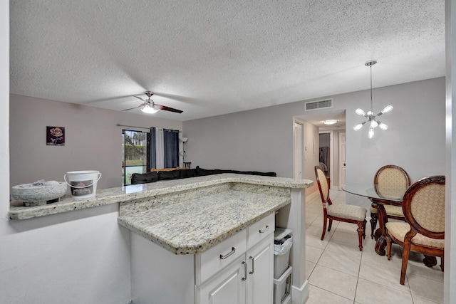 9441 W Mcnab Rd Unit 111, Tamarac, FL 33321 - kitchen with light tile patterned flooring, light stone countertops, pendant lighting, white cabinets, and a ceiling fan