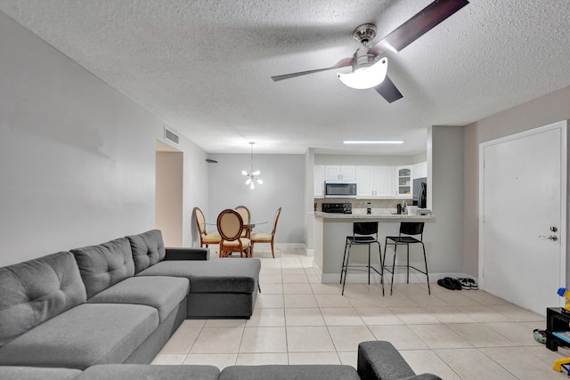 9441 W Mcnab Rd Unit 111, Tamarac, FL 33321 - living room with a textured ceiling, light tile patterned floors, a ceiling fan, and a chandelier
