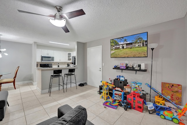 9441 W Mcnab Rd Unit 111, Tamarac, FL 33321 - rec room with light tile patterned floors, a textured ceiling, ceiling fan, and baseboards