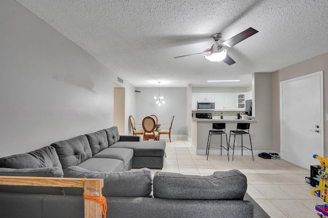 9441 W Mcnab Rd Unit 111, Tamarac, FL 33321 - living area featuring a chandelier, light tile patterned floors, a textured ceiling, ceiling fan, and baseboards