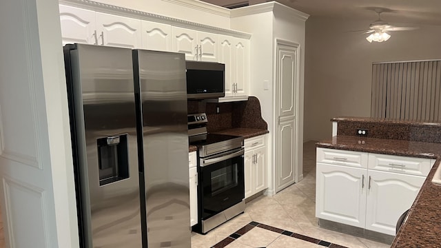 kitchen featuring a ceiling fan, dark stone countertops, light tile patterned floors, stainless steel appliances, and white cabinets