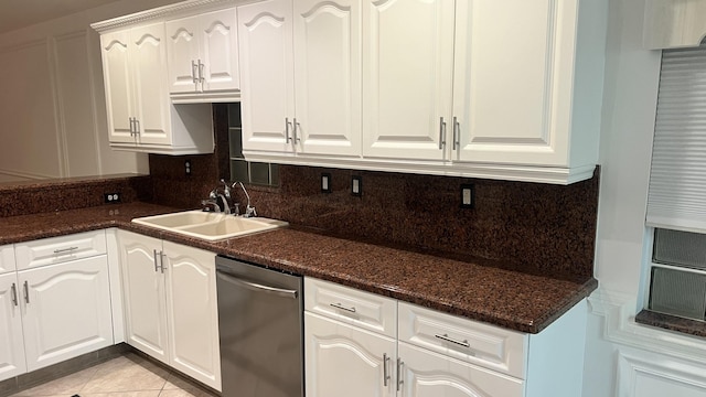 kitchen featuring light tile patterned flooring, a sink, white cabinetry, tasteful backsplash, and stainless steel dishwasher