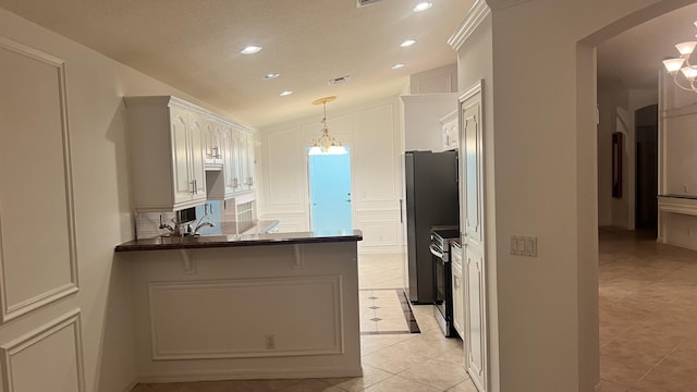 kitchen with visible vents, a chandelier, a peninsula, stainless steel appliances, and pendant lighting