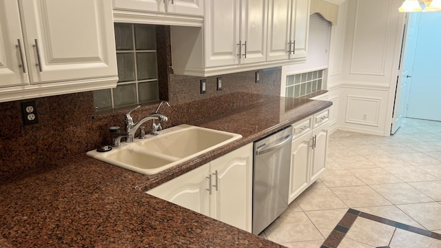 kitchen featuring dishwasher, light tile patterned floors, a sink, and backsplash