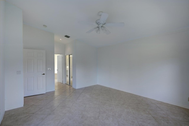 empty room featuring vaulted ceiling, visible vents, ceiling fan, and light tile patterned floors