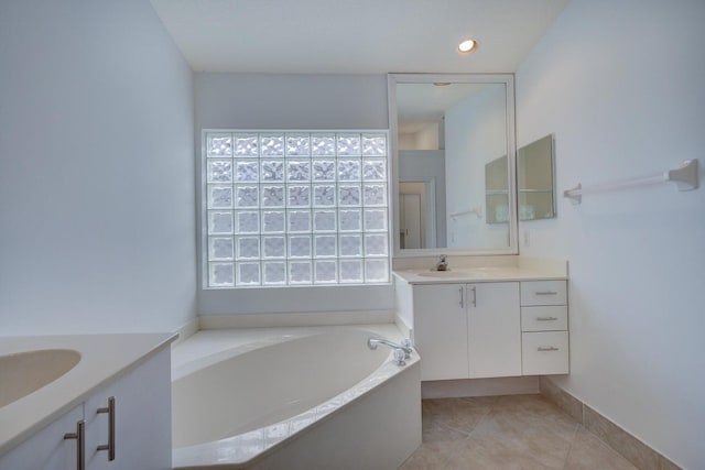 bathroom featuring plenty of natural light, tile patterned floors, a sink, and two vanities