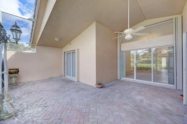 view of patio / terrace featuring glass enclosure and ceiling fan