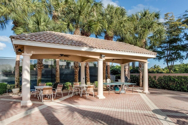 surrounding community with outdoor dining space, fence, and a gazebo