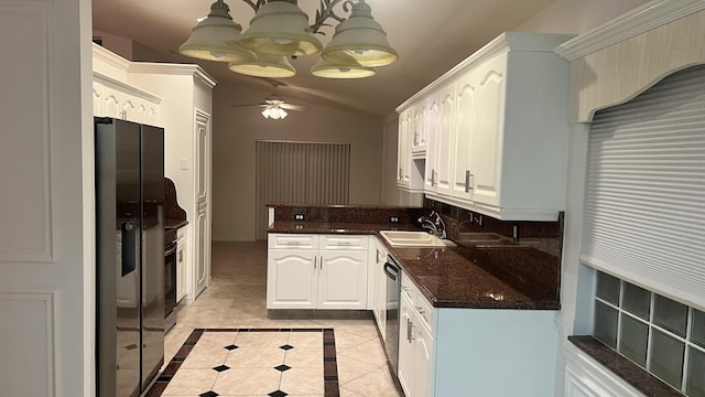 kitchen featuring stainless steel appliances, lofted ceiling, a sink, ceiling fan with notable chandelier, and light tile patterned floors