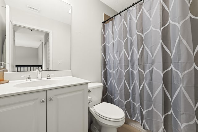bathroom with toilet, vanity, and a shower with curtain