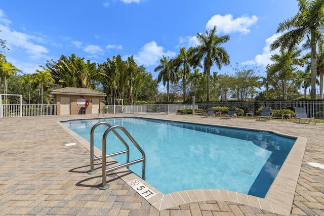 community pool featuring fence and a patio area