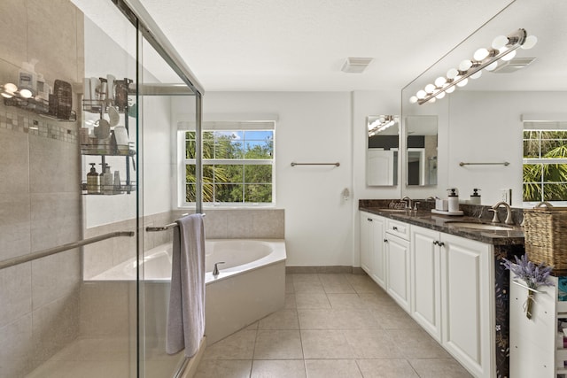 full bath with a stall shower, a garden tub, tile patterned floors, and double vanity
