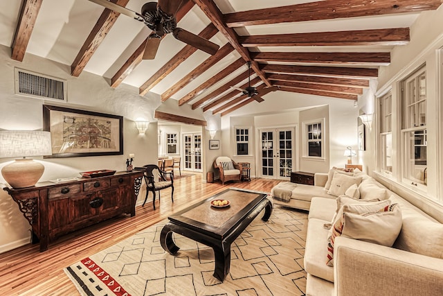 living area featuring vaulted ceiling with beams, a ceiling fan, light wood finished floors, and visible vents