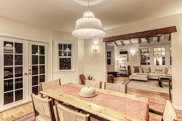 dining area featuring wood-type flooring, french doors, and beam ceiling