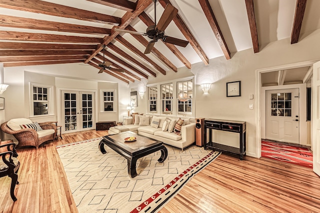 living area with vaulted ceiling with beams, ceiling fan, french doors, and light wood finished floors
