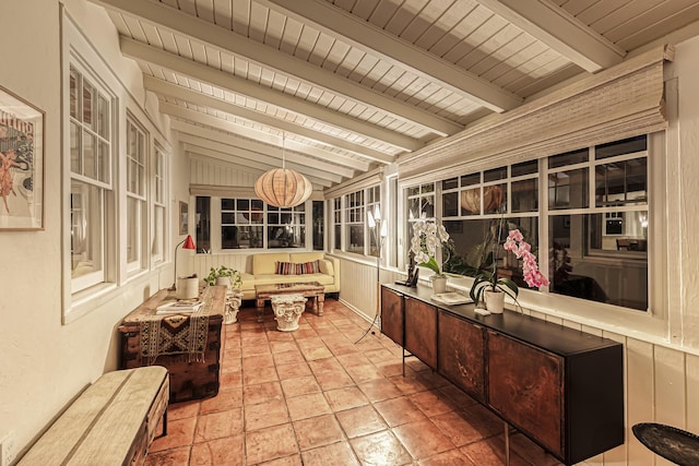 sunroom with vaulted ceiling with beams and stone tile flooring
