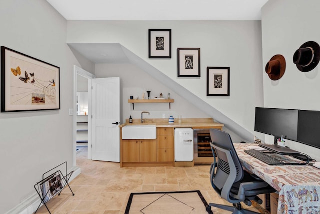 home office with indoor wet bar, stone tile floors, and a sink