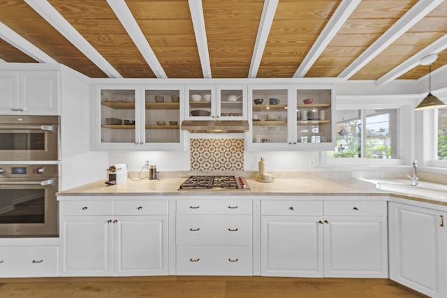 kitchen featuring beam ceiling, white cabinets, wooden ceiling, and stainless steel appliances