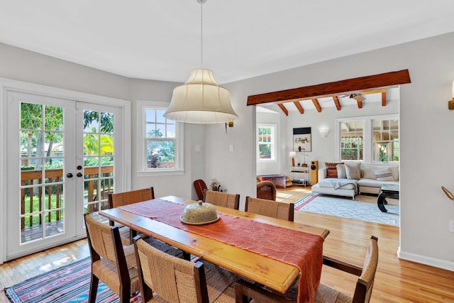 dining area with light wood-style flooring, french doors, and beam ceiling