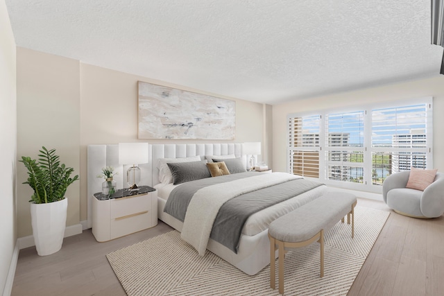 4001 N Ocean Blvd Unit 1602, Boca Raton, FL 33431 - bedroom featuring light wood-style floors, a textured ceiling, and baseboards