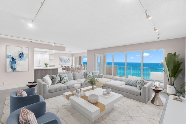 4001 N Ocean Blvd Unit 1602, Boca Raton, FL 33431 - living room featuring track lighting, a water view, and baseboards