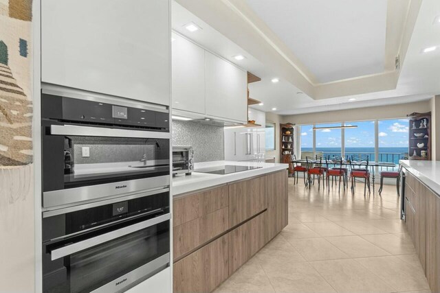 4001 N Ocean Blvd Unit 1602, Boca Raton, FL 33431 - kitchen with stainless steel oven, modern cabinets, open shelves, light countertops, and recessed lighting
