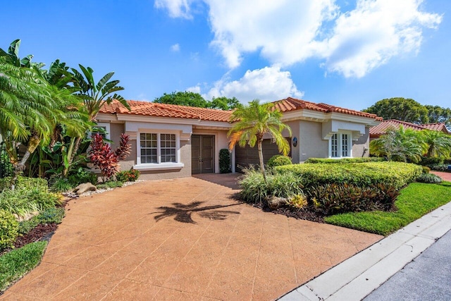 6349 NW 23rd St, Boca Raton, FL 33434 - mediterranean / spanish house featuring stucco siding, a tile roof, a garage, and driveway