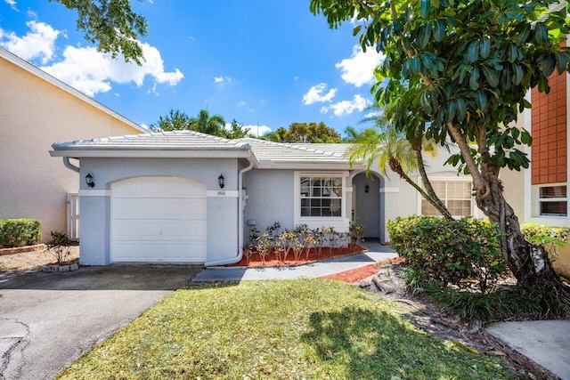 ranch-style home featuring an attached garage, aphalt driveway, a tiled roof, and stucco siding