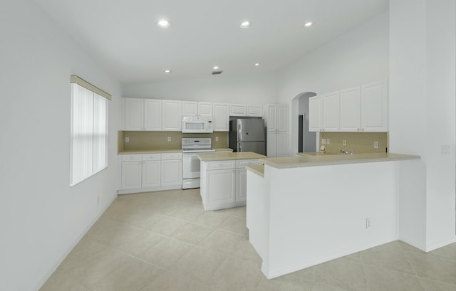 7130 Catania Dr, Boynton Beach, FL 33472 - kitchen with light countertops, white cabinets, white appliances, arched walkways, and vaulted ceiling