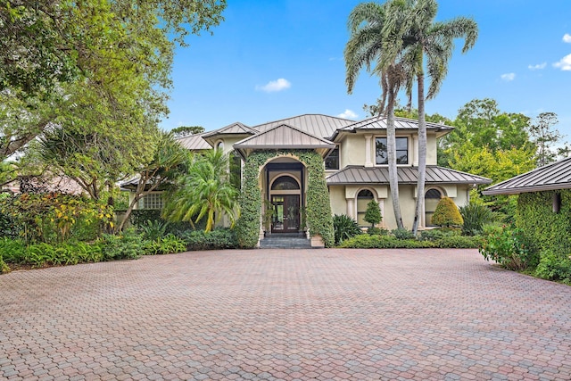 mediterranean / spanish-style home featuring metal roof, a standing seam roof, and stucco siding