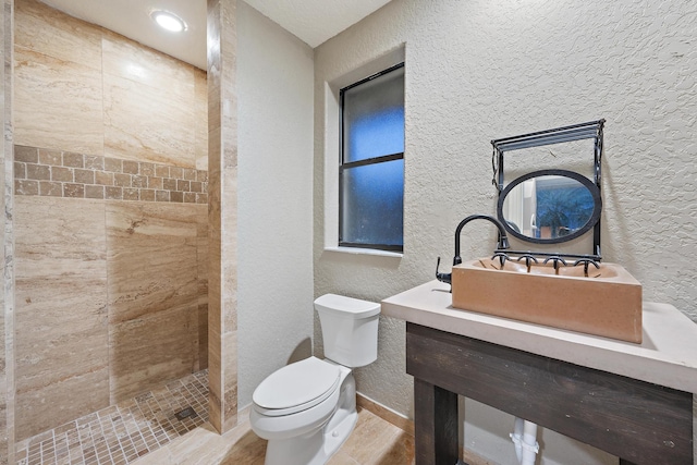 18907 SE Loxahatchee River Rd, Jupiter, FL 33458 - full bathroom featuring a textured wall, toilet, tiled shower, vanity, and baseboards